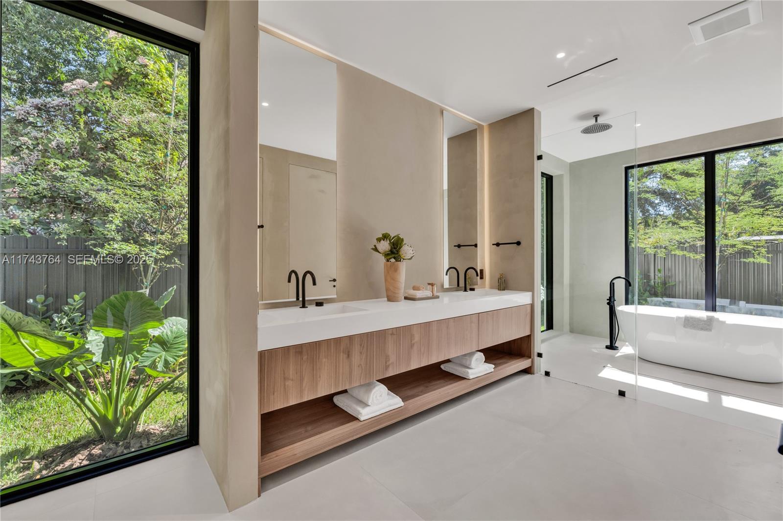 Yüzer ahşap çift lavabolu, serbest duran küvetli ve cam duşlu ana banyo, bahçe pencereleri